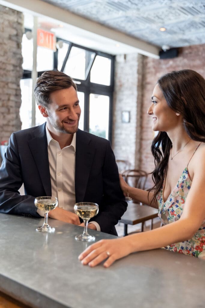Engaged couple smile at the bar at Vin Sur Vingt on Manhattan's Upper West Side.