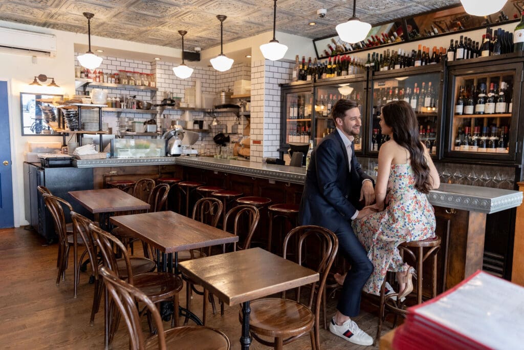 Engaged couple smiling at the bar at Vin Sur Vingt on Manhattan's Upper West Side.