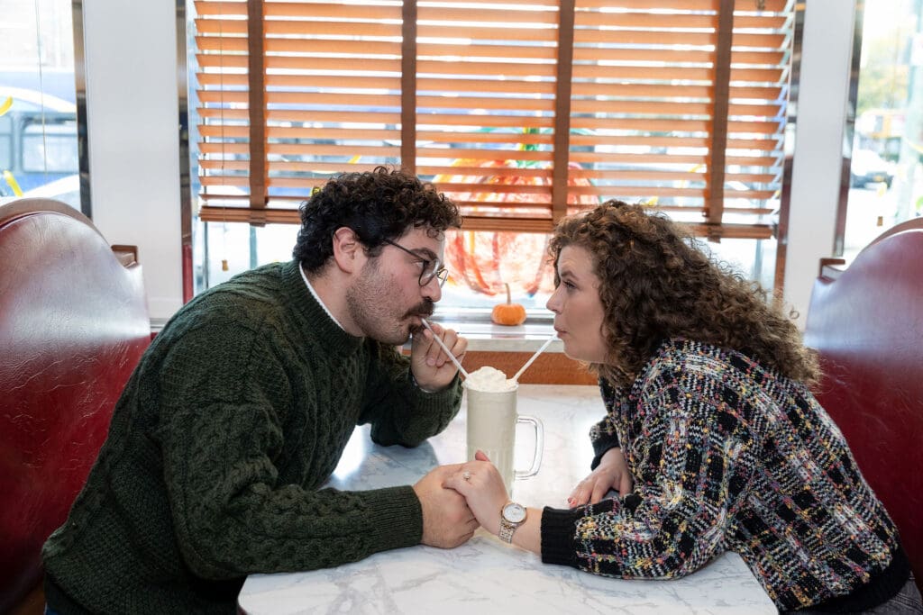 Engaged couple enjoy milkshakes in at Bel-Aire Diner in Astoria, Queens during their casual pre-wedding portrait session in NYC.