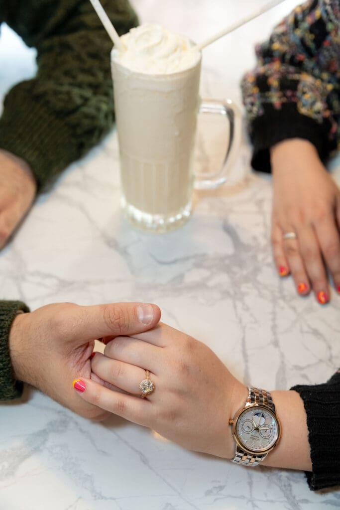 Engaged couple enjoy milkshakes in at Bel-Aire Diner in Astoria, Queens during their casual pre-wedding portrait session in NYC.