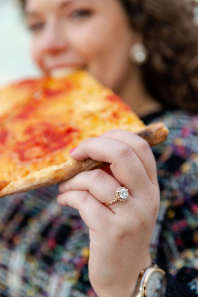 Engaged couple eat pizza at sunset at Hallett's Cove in Astoria, Queens for their fall engagement session.