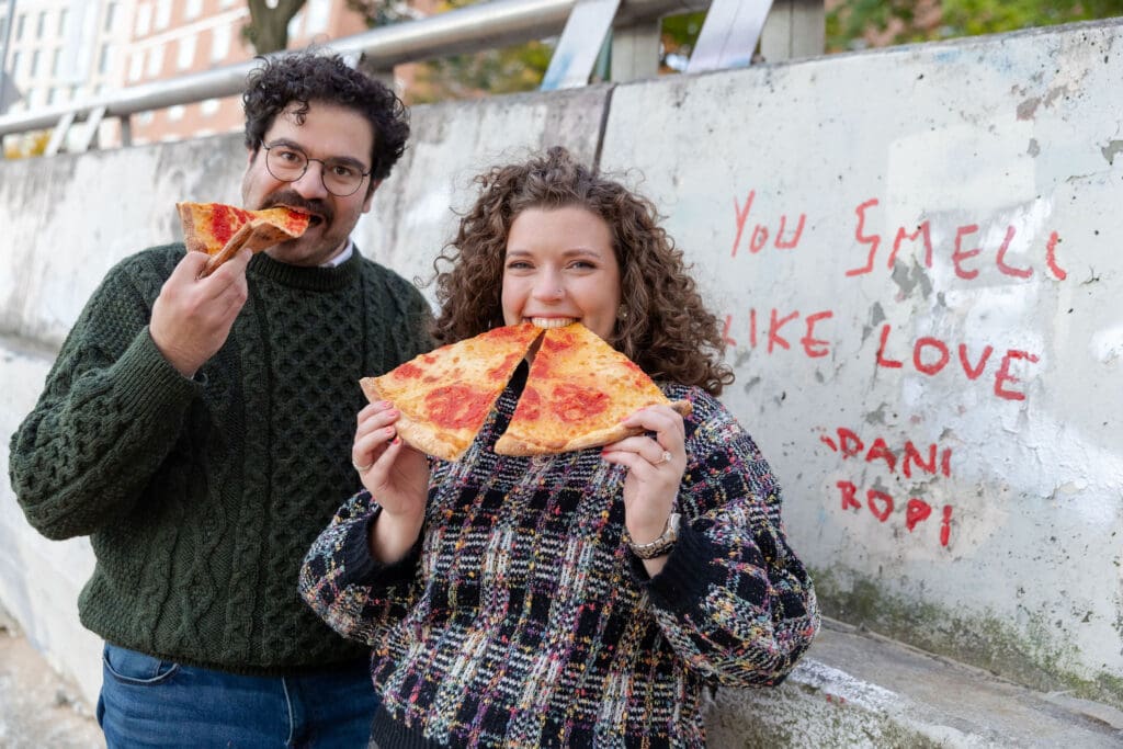 Engaged couple eat pizza at sunset at Hallett's Cove in Astoria, Queens for their fall engagement session.