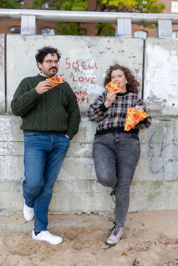 Engaged couple eat pizza at sunset at Hallett's Cove in Astoria, Queens for their fall engagement session.