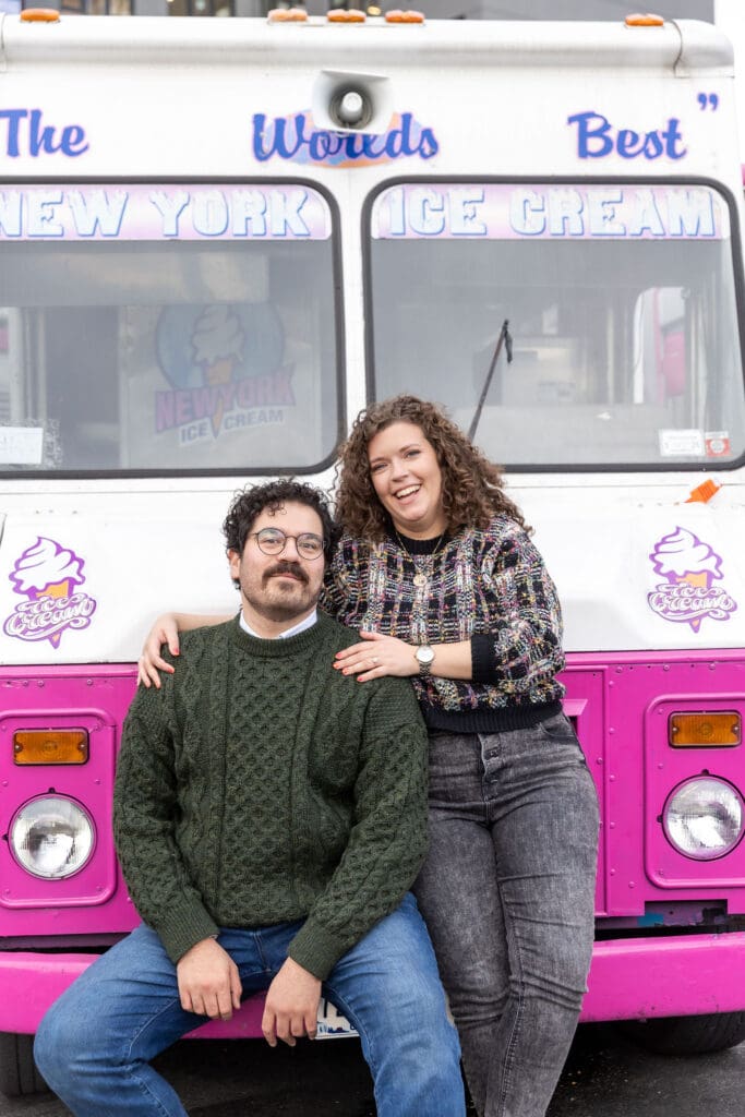 Engaged couple pose near ice cream trucks in Astoria, Queens for their fall engagement session.